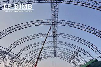 Why are tubular trusses widely used in large-space buildings?